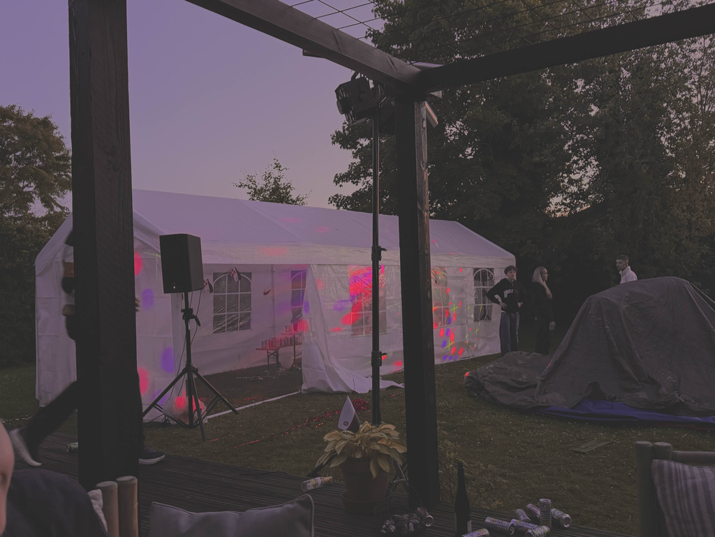Højttalere og lysstativer sat op til fest i skumringen