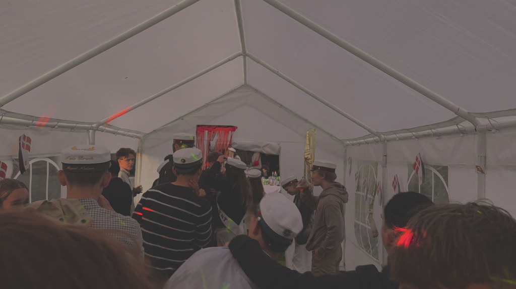 Fyldt festtelt med gæster der synger og danser